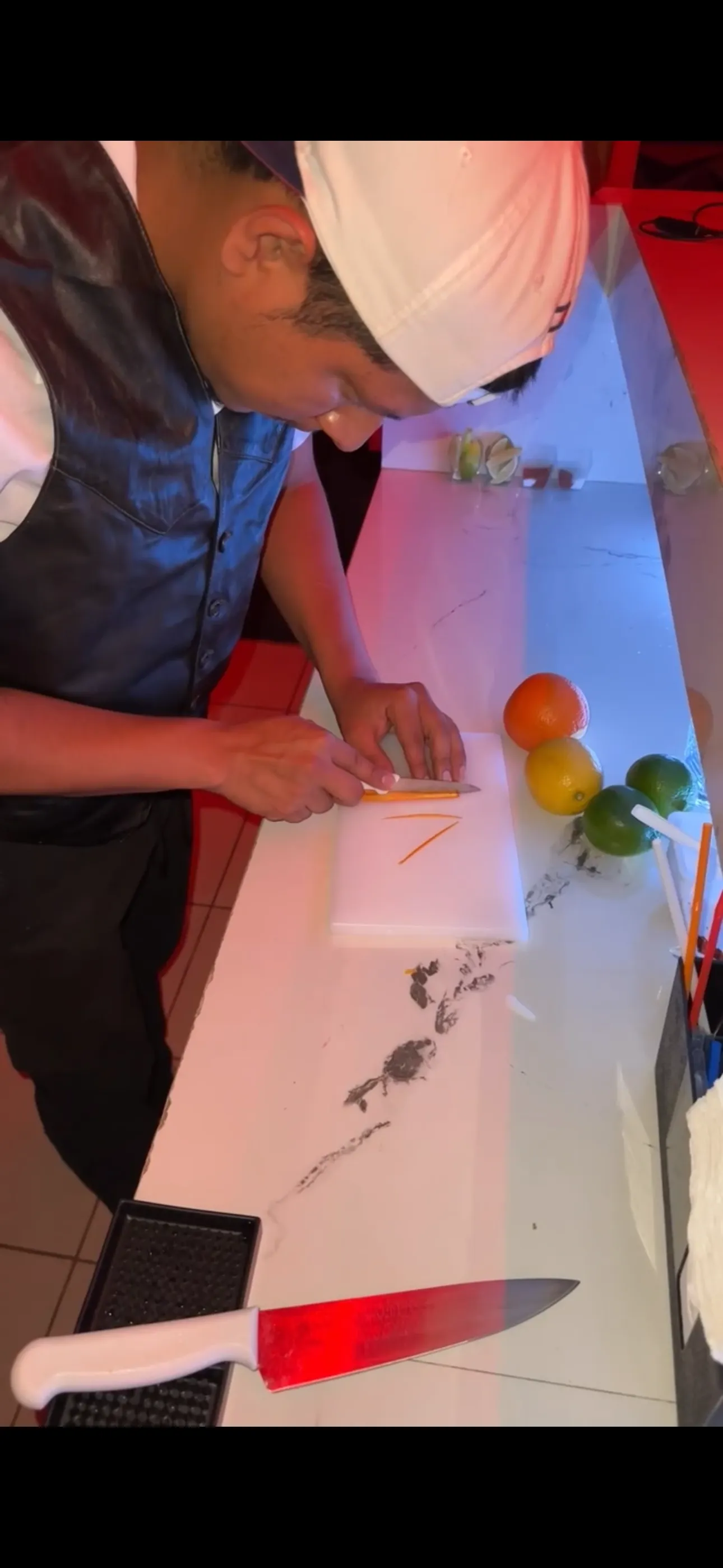 Bartender cutting citrus to prepare cocktails