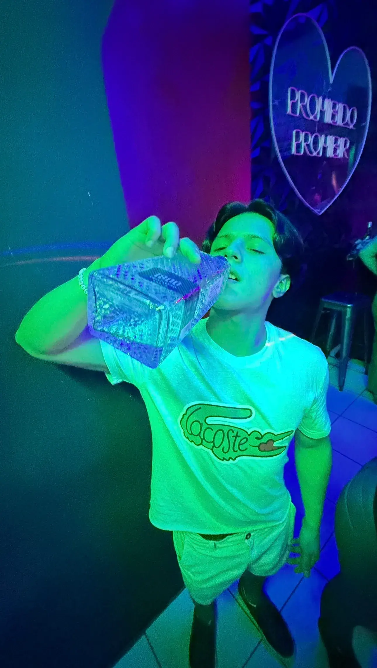 Guest with a bottle in front of the bar neon lights