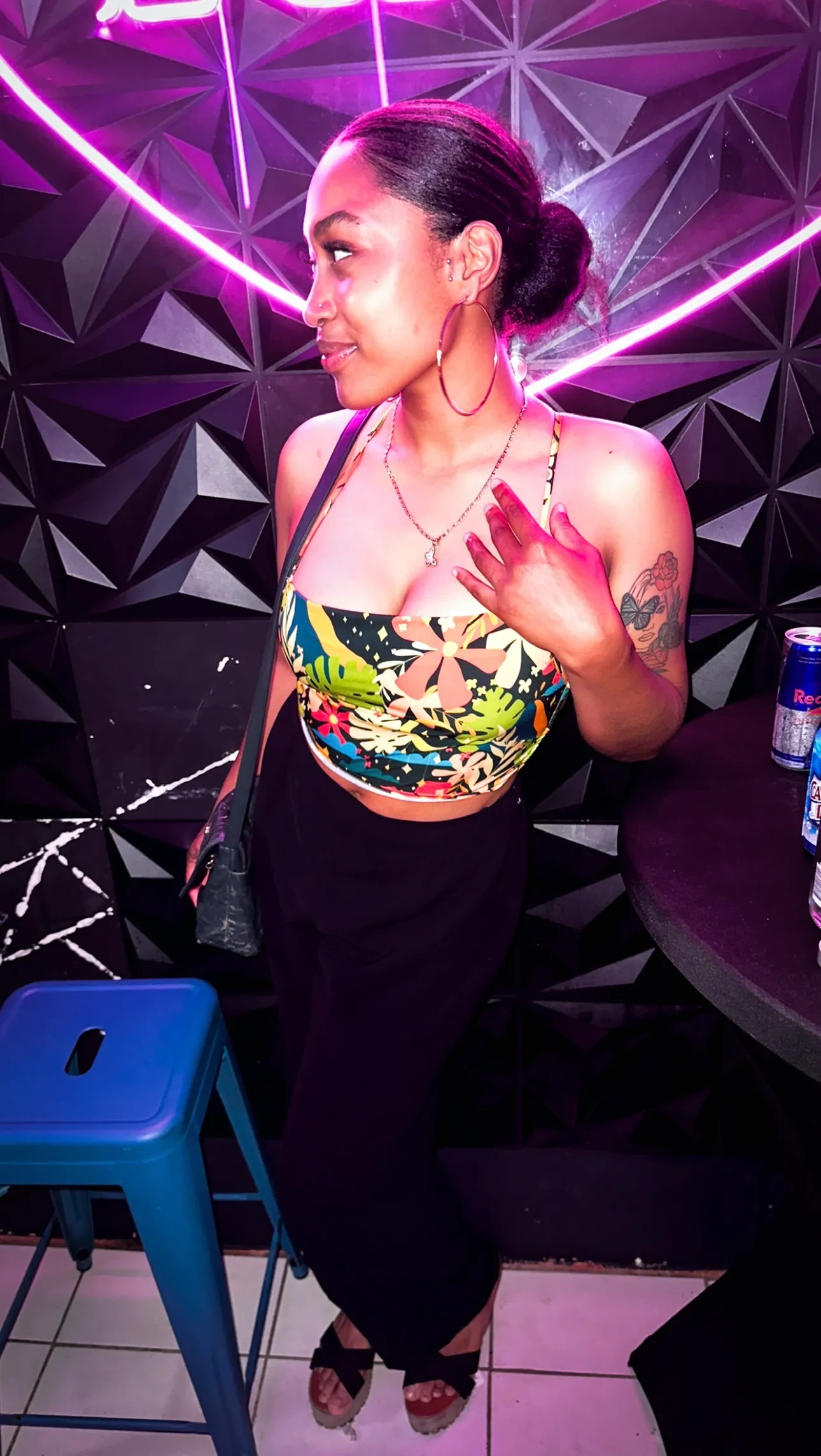 Customer posing next to a geometric wall with neon