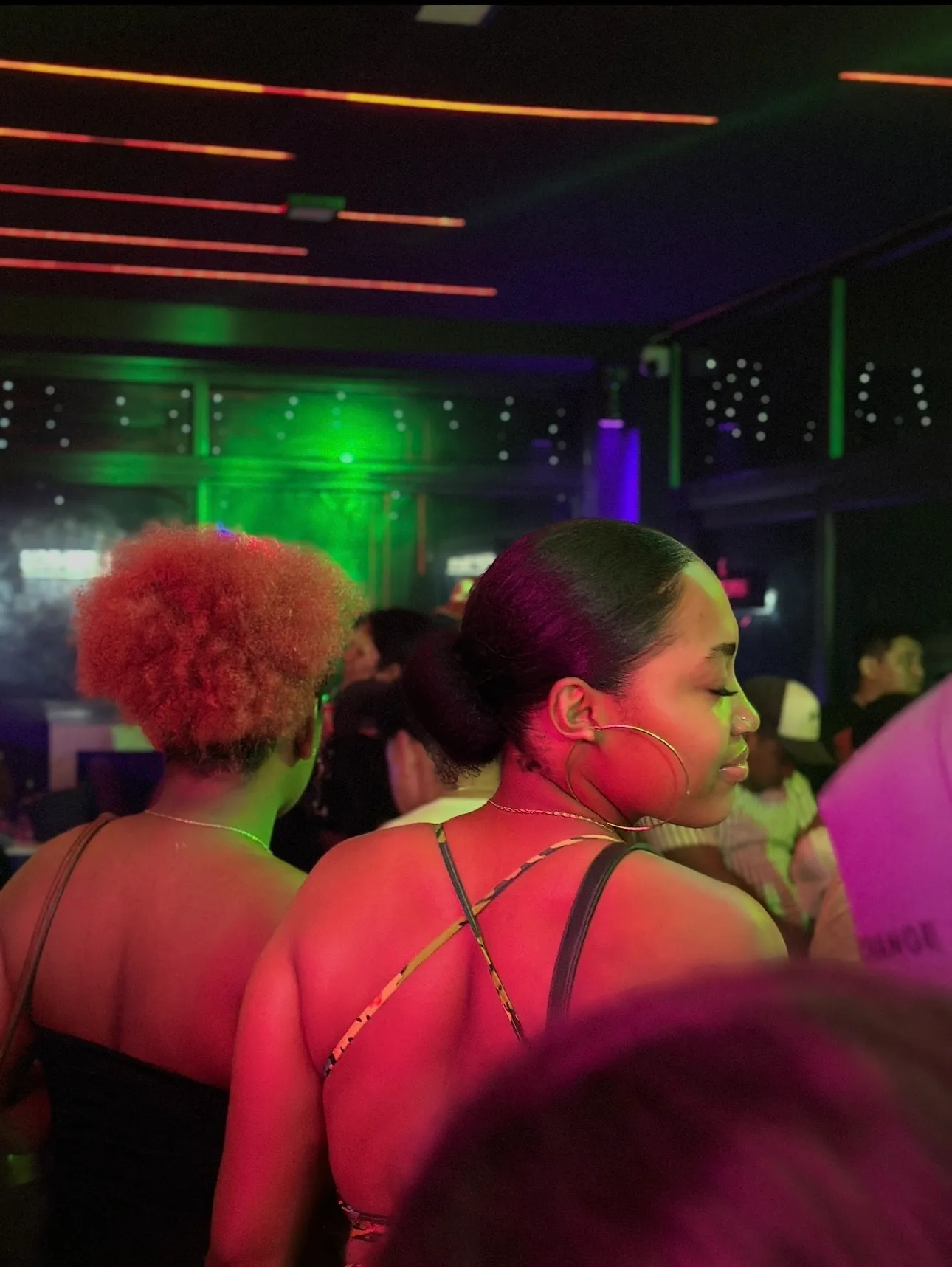Customer enjoying the bar under green neon lights