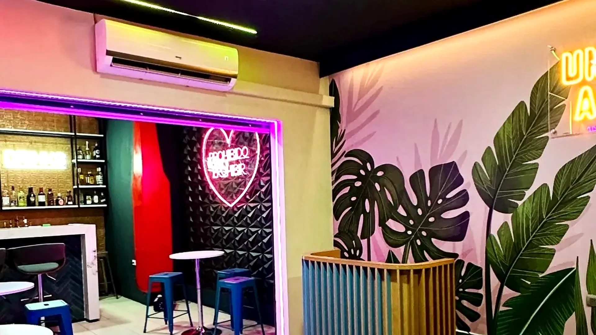The real interior of Single's Bar with tables and a tropical mural